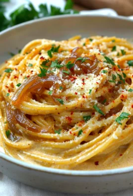 Creamy caramelized onion pasta served in a bowl with herbs