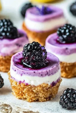 Mini blackberry lavender cheesecakes topped with fresh blackberries and lavender sprigs.