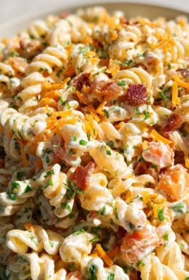 Bacon Ranch Pasta Salad garnished with fresh herbs in a bowl