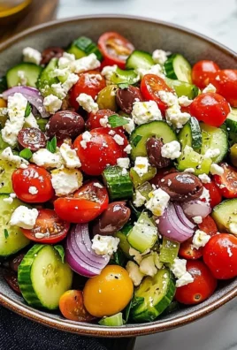 Colorful Greek salad with tomatoes, cucumbers, olives, and feta cheese.