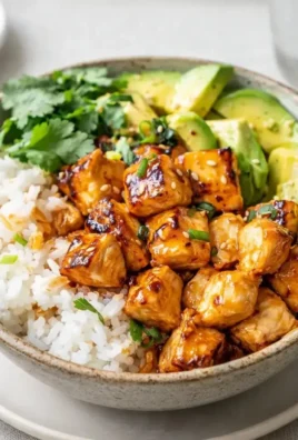 Delicious hot honey chicken bowls garnished with fresh vegetables and herbs