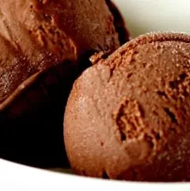 Bowl of chocolate avocado ice cream topped with cocoa and avocado slices