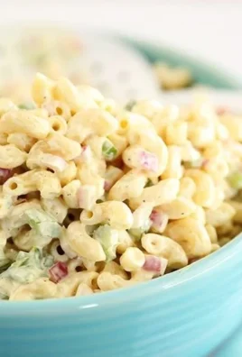Bowl of classic macaroni salad with vegetables and creamy dressing
