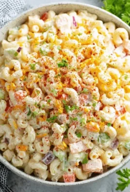 Bowl of classic creamy macaroni salad with colorful vegetables