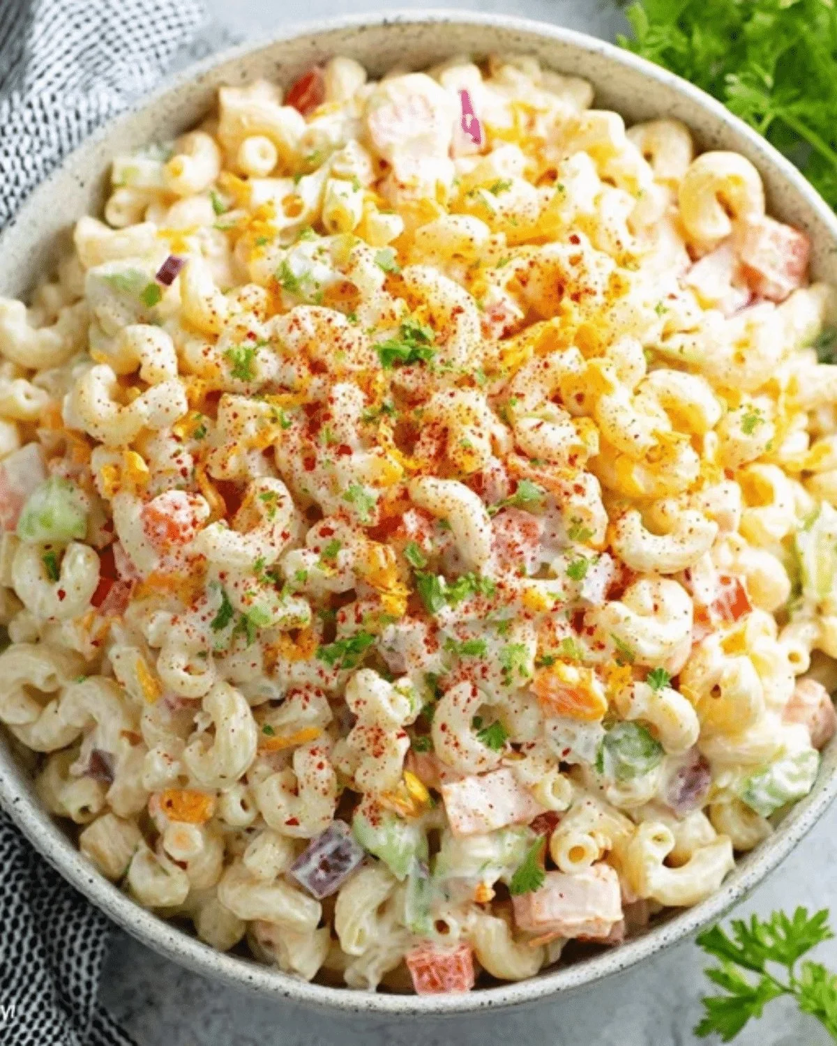 Bowl of classic creamy macaroni salad with colorful vegetables