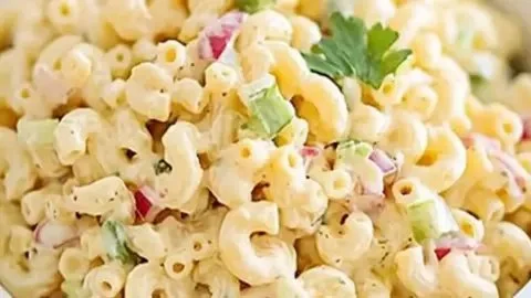 Classic macaroni salad served in a bowl at a summer picnic