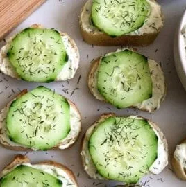 Cucumber Cream Cheese Bites served on a platter with mini baguettes