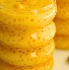 Dairy-free mango sago pudding served in a bowl with fresh mango pieces and sago pearls