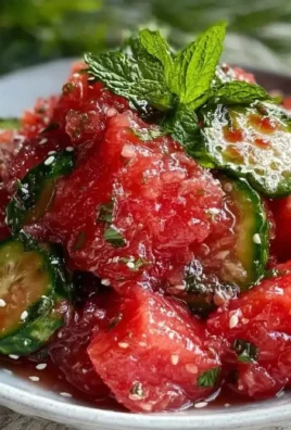 Fresh watermelon cucumber mint salad in a bowl, garnished with mint leaves.