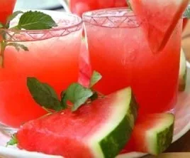 A refreshing glass of watermelon lemonade garnished with fresh mint leaves.