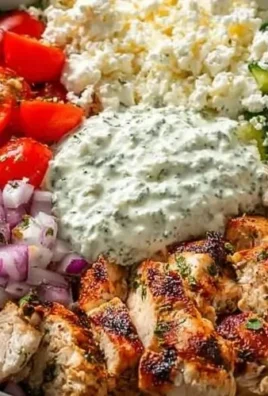 Healthy Greek Chicken Bowl with fresh vegetables, rice, and tzatziki sauce