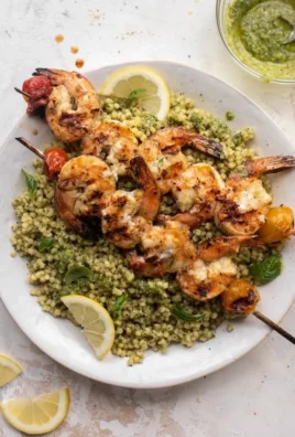Grilled lemon shrimp served with pesto couscous on a plate