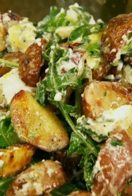Grilled potato salad topped with arugula and goat cheese drizzled with vinaigrette