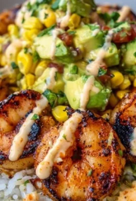 Grilled shrimp bowl with avocado corn salsa on a wooden table