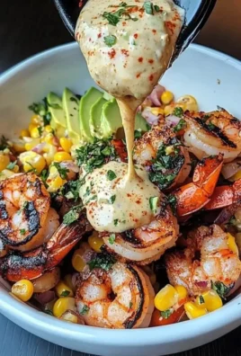 Delicious grilled shrimp bowl with avocado and corn salsa topped with creamy garlic sauce