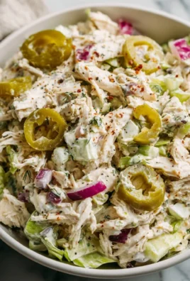 High protein pepperoncini chicken salad served in a bowl with fresh greens.