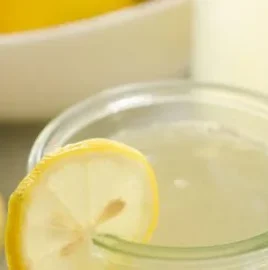 Refreshing glass of homemade lemonade with lemon slices and mint