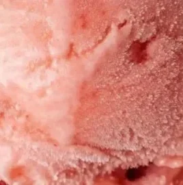 Bowl of homemade watermelon ice cream garnished with fresh mint leaves.