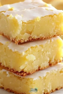 Zesty lemon brownies displayed on a plate with a lemon slice.