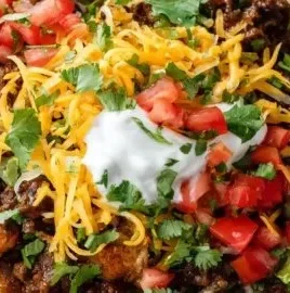 Loaded taco potato bowls topped with cheese, sour cream, and fresh toppings.