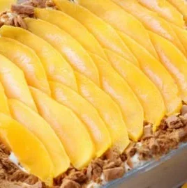 Creamy Mango Float dessert served in a glass, garnished with mango slices.