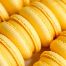 Delicious Mango Macarons with vibrant yellow color and mango filling on a plate.