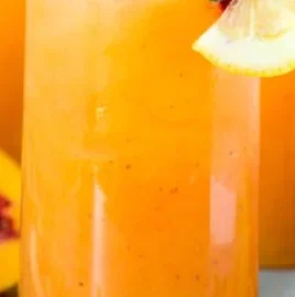 Refreshing glass of peach lemonade with fresh peaches and lemons