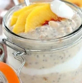 Bowl of peach overnight oats topped with fresh peach slices and almonds