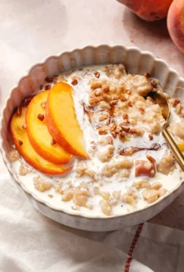 Bowl of Peaches and Cream Oatmeal topped with fresh peach slices and cream