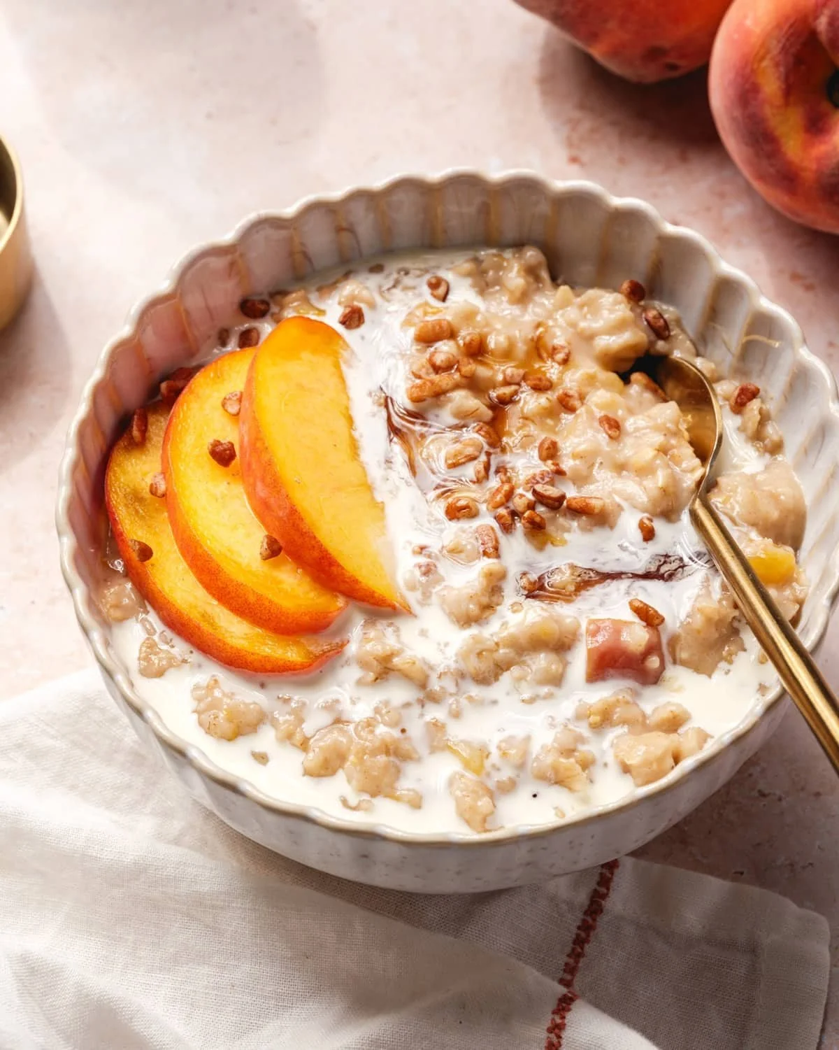 Bowl of Peaches and Cream Oatmeal topped with fresh peach slices and cream