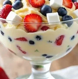 Delicious Red, White, and Blue Cheesecake Salad with fresh fruits and creamy topping
