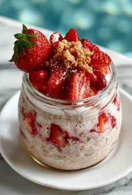 Delicious strawberry cheesecake overnight oats in a glass with fresh strawberries