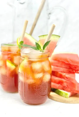 Refreshing watermelon iced tea in a glass with mint leaves.