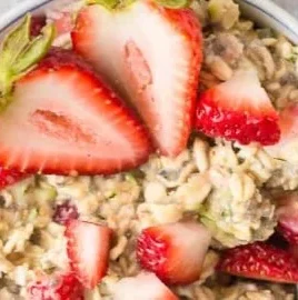 Bowl of Zucchini Strawberry Overnight Oats with fresh strawberries and zucchini slices
