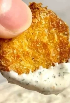 Crispy air fryer fried pickles served with dipping sauce on a plate.