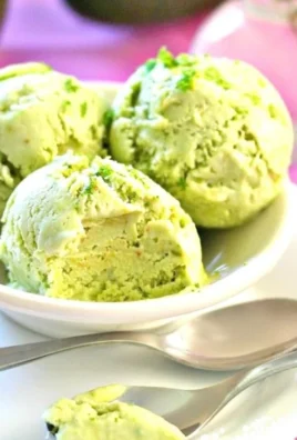 Delicious homemade avocado ice cream in a bowl topped with nuts and mint.