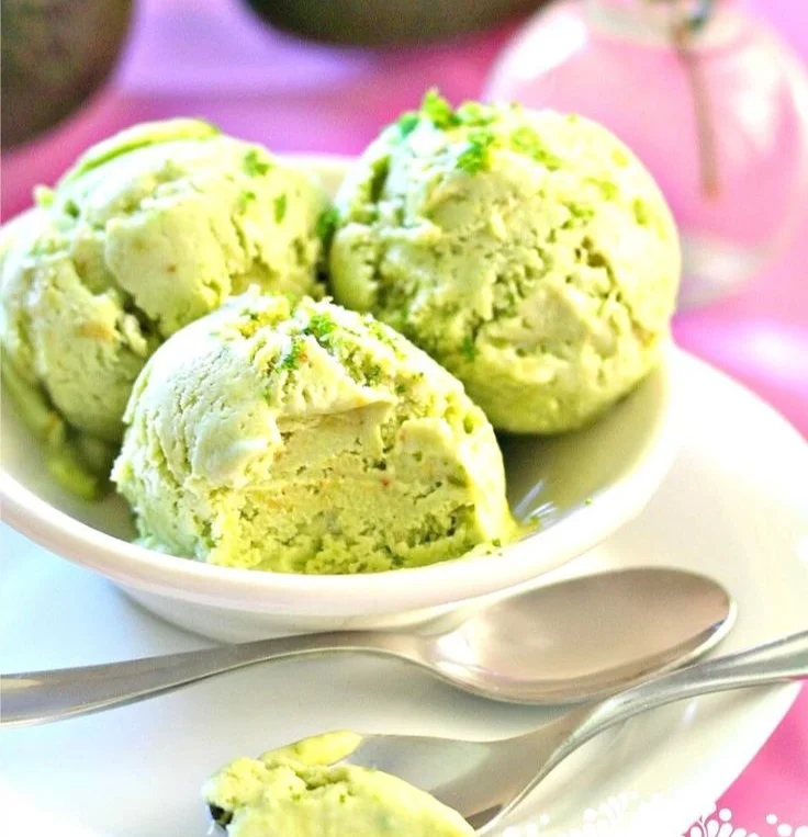 Delicious homemade avocado ice cream in a bowl topped with nuts and mint.