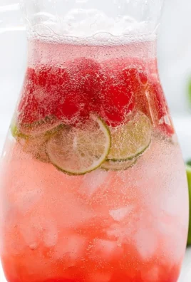 Chilled Cherry Limeade in a glass with fresh cherries and lime slices