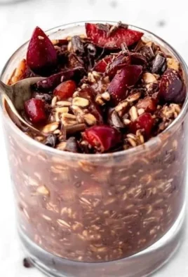 Bowl of Chocolate Cherry Overnight Oats topped with fresh cherries and chocolate flakes.