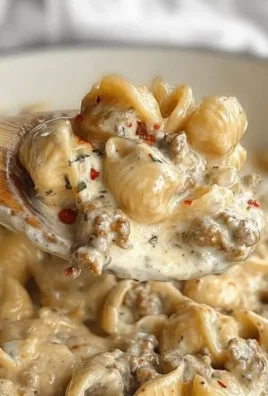 Delicious creamy Italian sausage pasta served in a bowl with herbs.