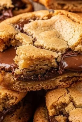 Gooey chocolate cookie bars served on a plate, topped with chocolate chips.