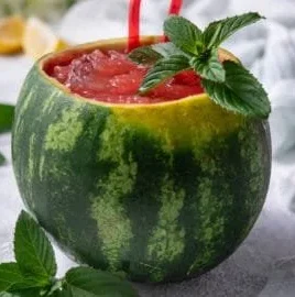 Delicious homemade watermelon slushie served in a glass with fresh watermelon slices.