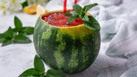 Delicious homemade watermelon slushie served in a glass with fresh watermelon slices.