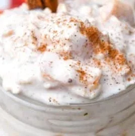 Bowl of Peaches & Cream Overnight Oats topped with fresh peaches and cream