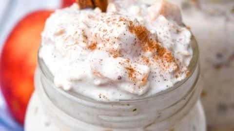 Bowl of Peaches & Cream Overnight Oats topped with fresh peaches and cream