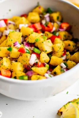 Fresh pineapple salsa served in a bowl with chips.