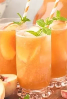 Glass of Southern Peach Tea with fresh peaches and mint leaves
