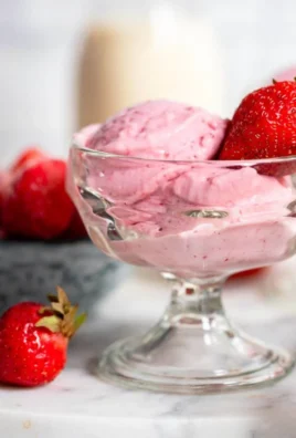 Delicious strawberry cottage cheese ice cream in a bowl, garnished with fresh strawberries.