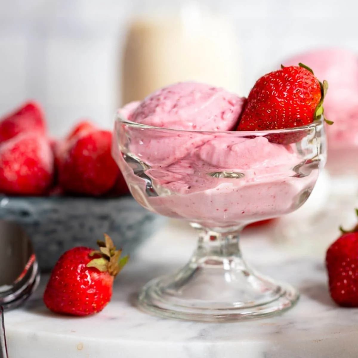 Delicious strawberry cottage cheese ice cream in a bowl, garnished with fresh strawberries.