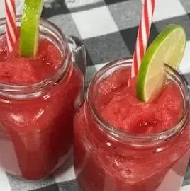 Refreshing watermelon slushie in a glass with ice and mint leaves